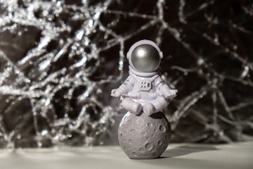 Plastic toy figure astronaut on silver background Copy space. Concept of out of earth travel,...