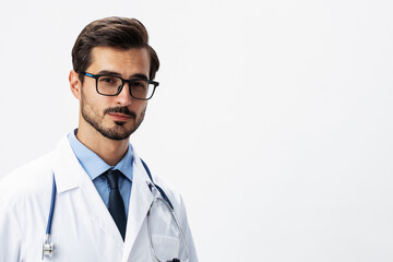 Male smile doctor in a white coat and eyeglasses and a stethoscope looks at the camera on a white isolated background, copy space, space for text, health