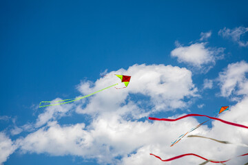 Kites flying in blue and cloudy sky, kite festival