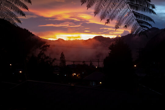 A rare sunset in Tembagapura high jungle mountains of Papua, Indonesia with clouds streaming down the mountains