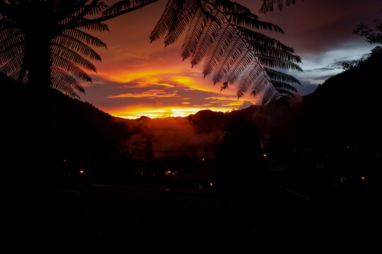 A rare sunset in Tembagapura high jungle mountains of Papua, Indonesia with clouds streaming down the mountains