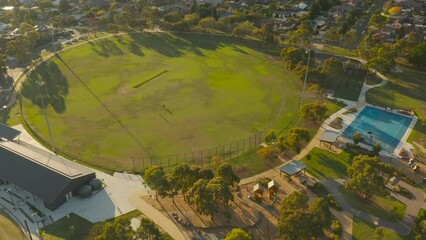 Aerial dive bomb perspective shows people using the oval space to train and practice leisurely activities in the evening.