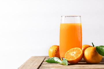 Natural orange juice with fresh fruit on wooden table.