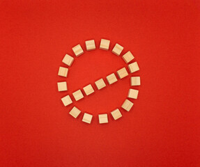 Fototapeta na wymiar 停止マークの形に並べたウッドキューブの赤い背景