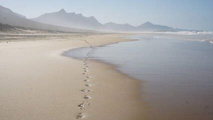 Fußspuren am Strand an der wilden und schöne Ostküste von Fuerteventura auf den Kanarischen...