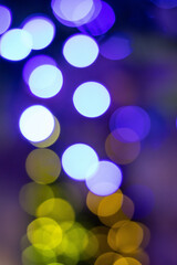 Abstract multicolored bokeh on a dark background. Beautiful vertical background with colorful bokeh on a black background