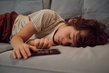 young boy sleeps on the couch at home. concept importance of setting healthy sleep habits in children and establishing regular routines to promote overall health and well-being