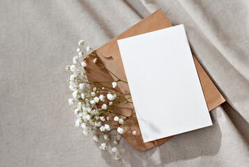 Blank paper card, postcard, envelope and flowers on neutral background, congratulation postcard or...