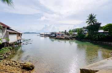 Obraz premium Wooden houses on stilts, tropical village on the sea shore.