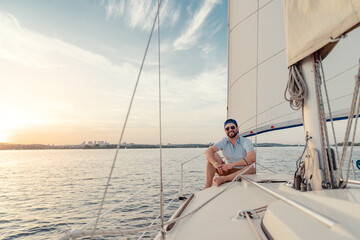 Luxury travel on the yacht. Young happy man on boat deck sailing the river.