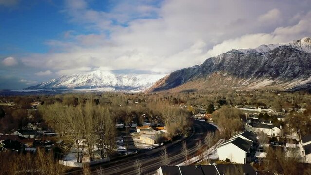 Pan up highway Ben Lomond Mountain Ogden SLC Utah afternoon blue gold yellow cars neighborhood drone mid winter Feb 2019