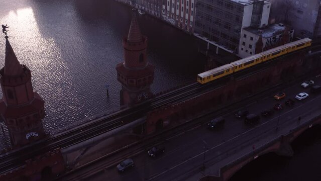 Historic Oberbaum bridge with yellow subway on track crossing over; aerial
