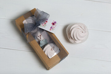 Homemade marshmallows in a cardboard box. Zephyr flowers. Box with transparent lid. Gift wrap. Tied with ribbon.