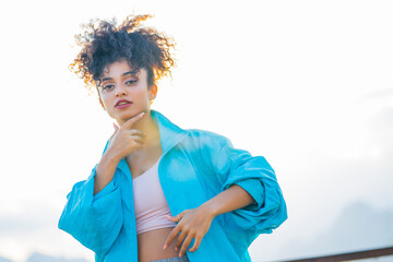 Close up portrait of a beautiful young mixed race woman with afro hairstyle in blue coat © yurakrasil