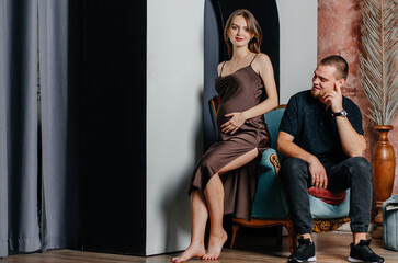 Obraz premium a pregnant woman and a man are sitting in a chair