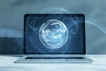 Close up of laptop on desktop with polygonal globe hologram on blurry background. World map with global social network. Future concept. Blue futuristic background with planet. Double exposure. © Who is Danny