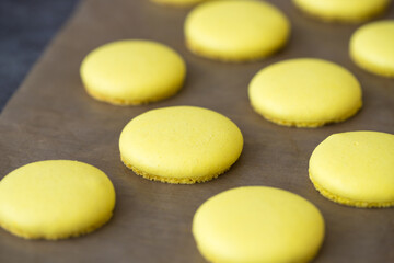 yellow halves for macaroons cookies on the table. home bakery concept.