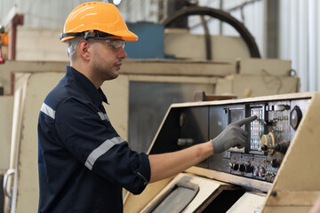 Factory male worker at work in the industry factory, work with CNC machine. Factory engineer male worker maintaining machine in the industrial factory