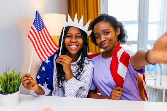 two happy african american sister celebrating usa independence day at home in cozy apartment