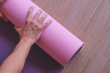 Close up of male hands on pink yoga mat. Yoga concept