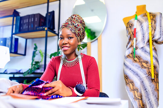african american dressmaker woman working with color samples for selection new clothing collection - Powered by Adobe