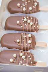 marshmallows in chocolate on a stick on the kitchen table. home bakery concept.