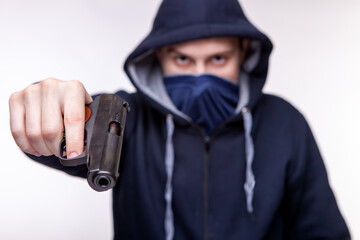 a man holds a gun in his hands and threatens. Bandit with a gun. Robber threatens with a gun