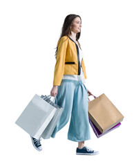 Smiling woman walking and holding shopping bags - 580977387