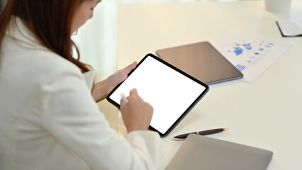 Fototapeta na wymiar Side view of young woman office worker using stylus pen writing on blank digital tablet screen
