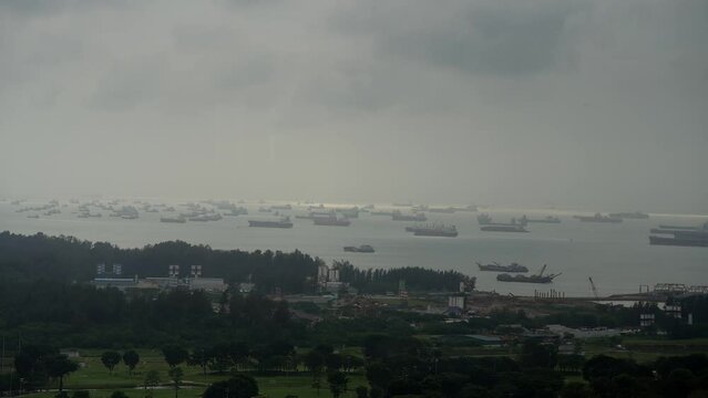 4K time lapse video during a cloudy morning in Singapore, view to Marina South harbour and a lot of cargo ships vessels