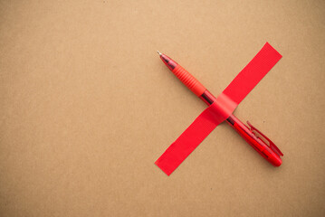 Red pen with taped X on wooden paper background copy space. Abstract of world press freedom day, human rights or censorship mass communication concept. © pla2na