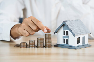 House model and coin holder money on the table for finance and banking concepts. Property investment mortgage and home rental concept earning from home