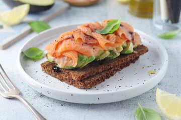 A rye bread sandwich with avocado and salmon