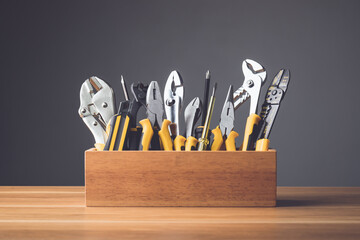 Set of tools for repair concept. Several yellow metal tools kit for self work in wooden box put on...