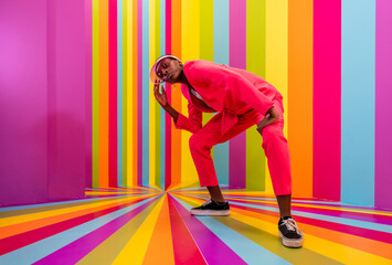 Beautiful african american young woman dancer having fun inside a rainbow box room - Cool and stylish black adult female portrait on colorful background, influencer creating content for social media