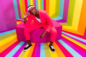 Beautiful african american young woman dancer having fun inside a rainbow box room - Cool and...