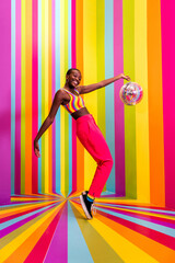 Beautiful african american young woman dancer having fun inside a rainbow box room - Cool and...