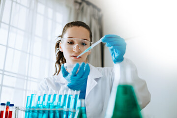 Female biotechnologist testing new chemical substances in laboratory.