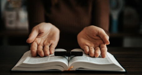 Woman praying on holy bible in the morning.Woman hand with Bible praying. Christian life crisis prayer