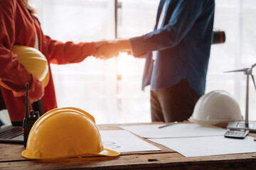 Young couple asian architects shake hands while working for teamwork, successful cooperation concept.