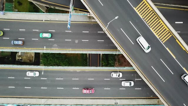 Topview drone shot of cars driving the busy highway intersection and freeway bridges of Chongqing, Huangjuewan, China, during daytime.
