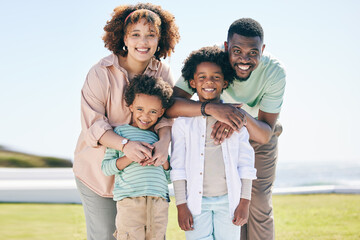 Love, happy and portrait of a family at the beach on a summer vacation, adventure or weekend trip. Happiness, smile and parents posing and bonding with boy children by the ocean while on holiday.