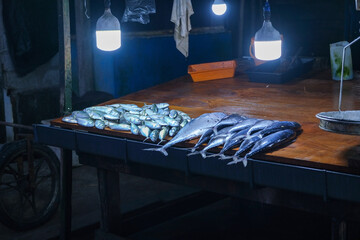 A table of fish and other seafood on counter of market
