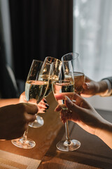 Cheers. People celebrate and raise glasses of sparkling wine for toast. Group of man and woman cheering with champagne. Friends are drinking at a party. Сloseup.