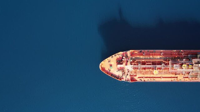 Industrial crude oil - fuel tanker ship anchored in deep blue, top down aerial shot