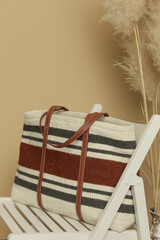 Obraz na płótnie Canvas Big wool striped tote bag on white chair