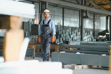 Fototapeta na wymiar Profesional fabric worker. Metal processing plant. A worker at a metal profile warehouse.