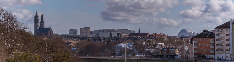 Obraz premium Hazy skyline over the districts Södermalm and Hammarby, churches and the Globen arena Avicii, a snowy sunny spring day in Stockholm