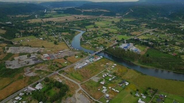 Aerial View Over Winding Chamiza River With Local Town And Villages. Dolly Forward, Tilt Up