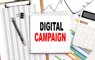DIGITAL CAMPAIGN text on notebook with chart, calculator and pen